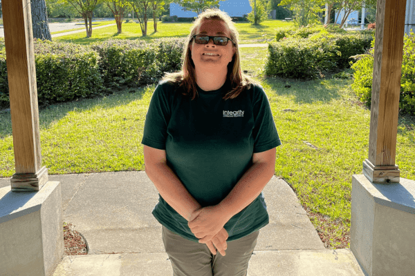 Integrity Contracting Solutions team member wearing a company polo shirt on a porch
