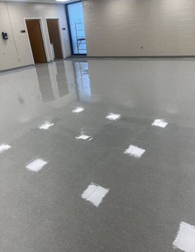 Reflective polished concrete floor in a commercial hallway with wooden doors