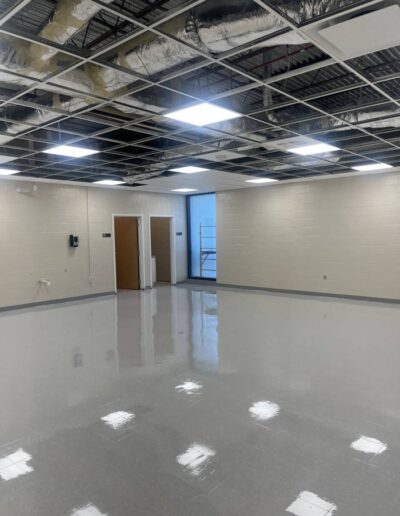 Polished gray concrete floor in an open commercial room with exposed ceiling