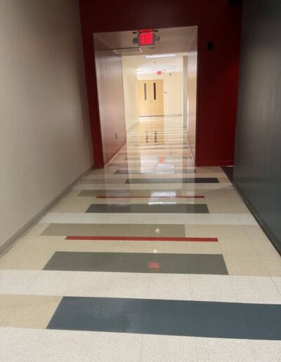 Clean, glossy terrazzo tile hallway with red accent walls after professional floor cleaning