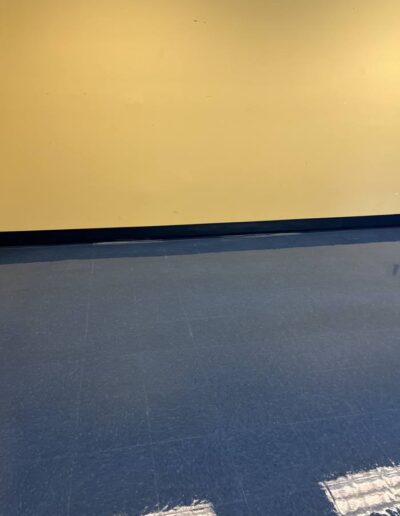Blue tile flooring with scuff marks before professional floor care service
